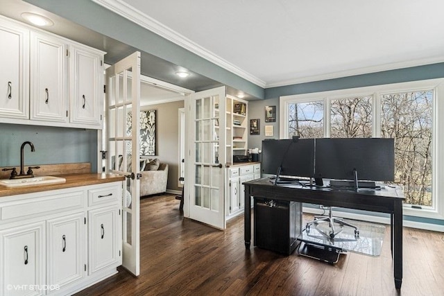 home office featuring french doors, a sink, baseboards, ornamental molding, and dark wood-type flooring