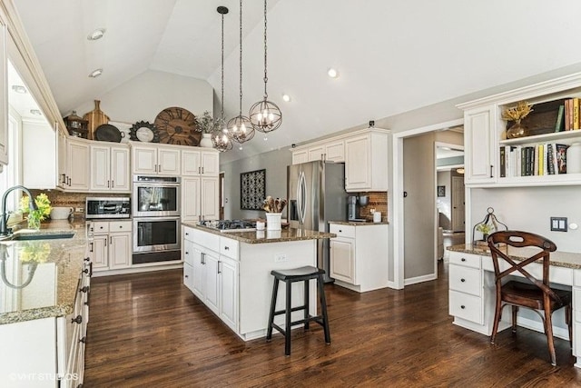 kitchen with a sink, a kitchen island, stainless steel appliances, and tasteful backsplash