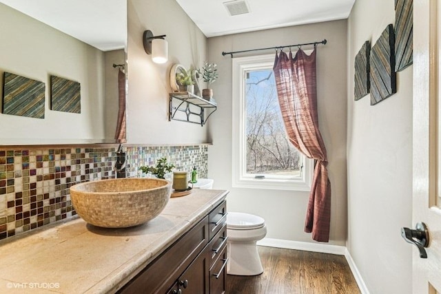 bathroom with visible vents, tasteful backsplash, wood finished floors, vanity, and toilet