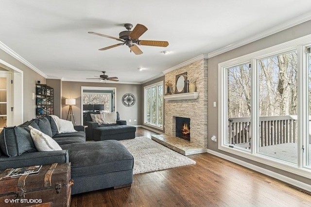 living area with baseboards, ceiling fan, wood finished floors, and a healthy amount of sunlight