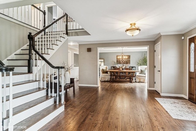 entryway featuring wood finished floors, stairway, baseboards, a notable chandelier, and ornamental molding