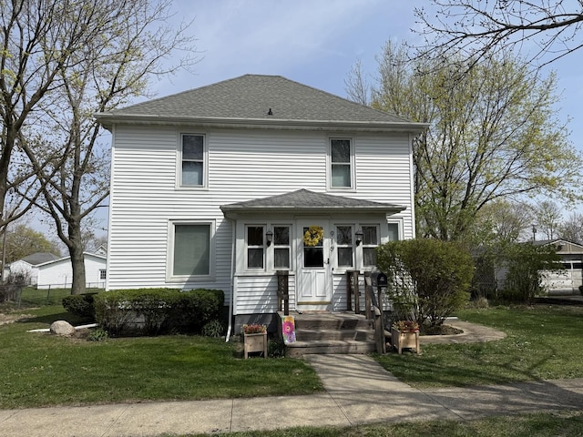 view of front of property with a front yard and roof with shingles