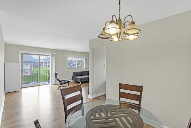 680 Marilyn Ave Unit 201, Glendale Heights, IL 60139 - dining space featuring a chandelier, light wood-style flooring, and baseboards