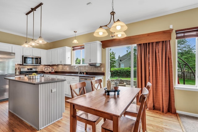 7817 Cascade Way, Gurnee, IL 60031 - kitchen featuring appliances with stainless steel finishes, dark countertops, plenty of natural light, white cabinetry, and crown molding