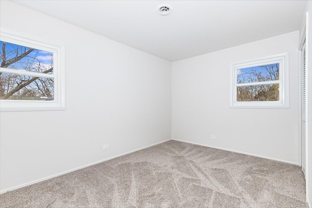 unfurnished room with visible vents, baseboards, and carpet floors