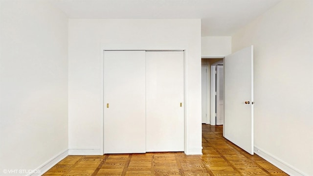 unfurnished bedroom featuring baseboards and a closet