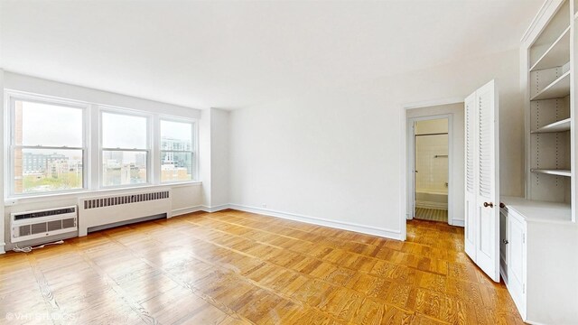 unfurnished room featuring baseboards and radiator heating unit