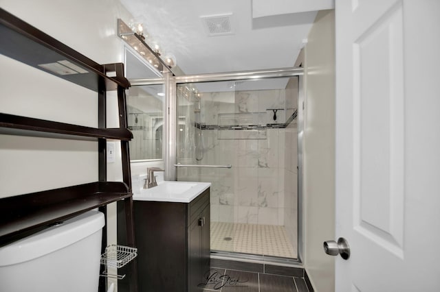 bathroom featuring visible vents, toilet, vanity, and a marble finish shower