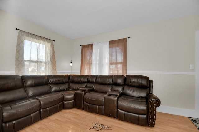 living area with baseboards and wood finished floors