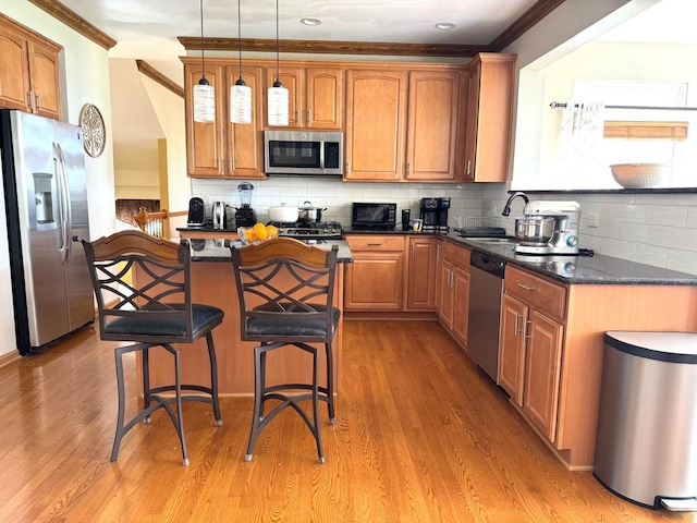 2115 Stafford Ct, Plainfield, IL 60586 - kitchen featuring a sink, a kitchen island, crown molding, a kitchen bar, and appliances with stainless steel finishes
