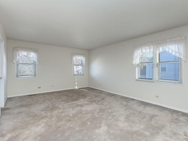carpeted empty room with baseboards