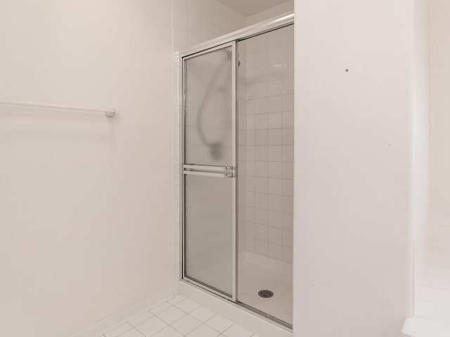 bathroom with a shower stall and tile patterned flooring
