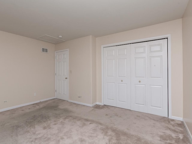 unfurnished bedroom featuring attic access, baseboards, visible vents, and carpet