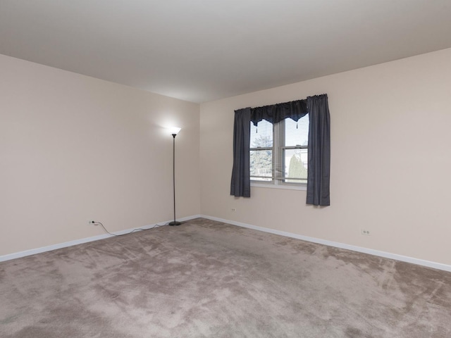 carpeted spare room with baseboards