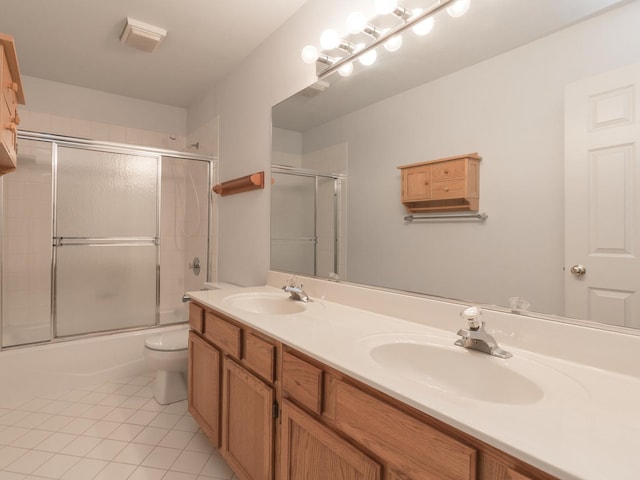full bath with toilet, tile patterned flooring, a sink, and double vanity