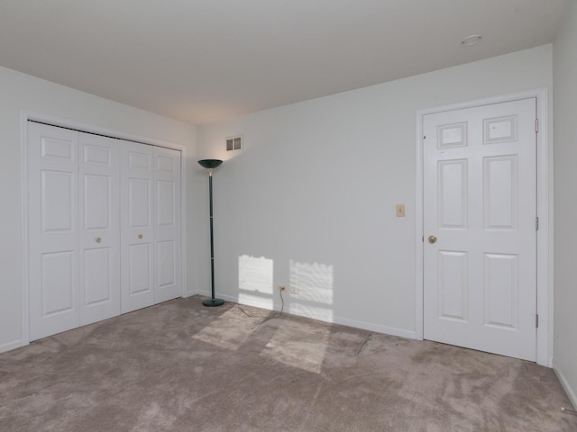 unfurnished bedroom with baseboards, carpet flooring, visible vents, and a closet