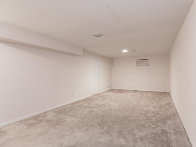 unfurnished room with light colored carpet and baseboards