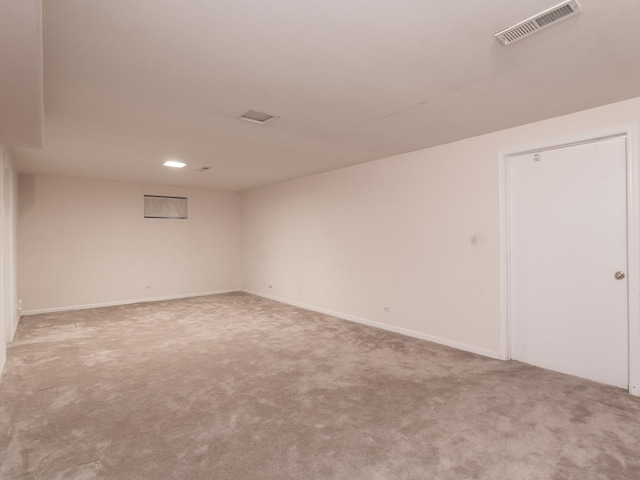 carpeted empty room featuring baseboards and visible vents