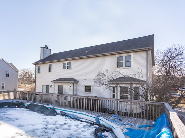 rear view of house featuring a wooden deck and a chimney