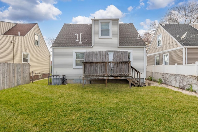 rear view of house featuring a yard, roof with shingles, a wooden deck, and a fenced backyard