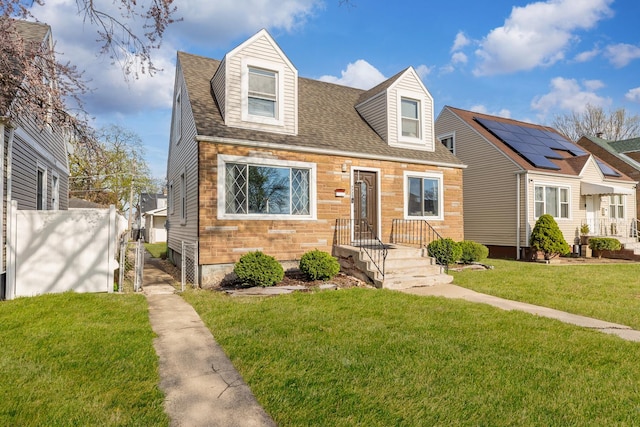 cape cod house with a front lawn, roof with shingles, and fence