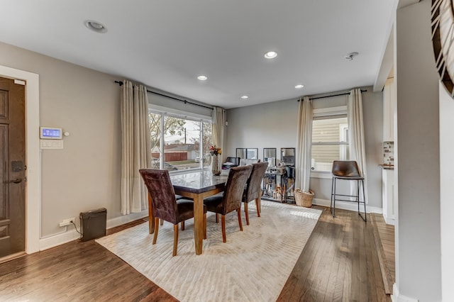 dining room featuring baseboards, hardwood / wood-style floors, and recessed lighting