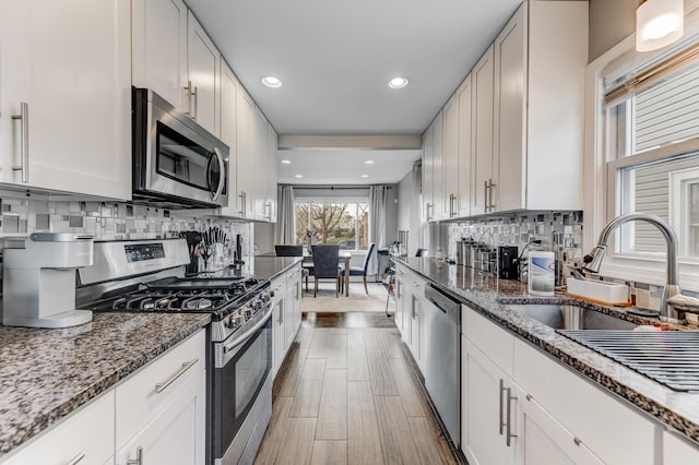 kitchen with stone countertops, stainless steel appliances, and backsplash