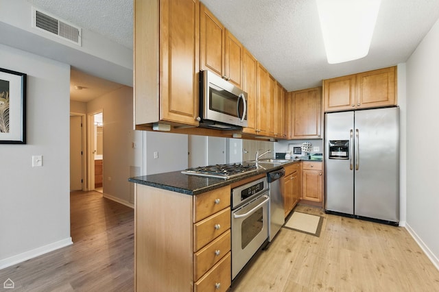 9715 Woods Dr Unit 805, Skokie, IL 60077 - kitchen featuring stainless steel appliances, light wood finished floors, and a textured ceiling