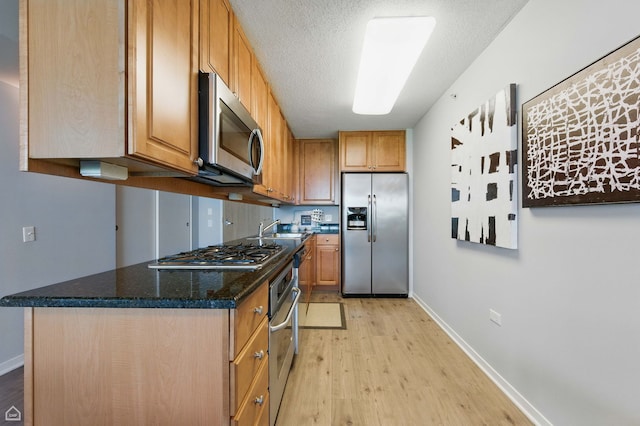 9715 Woods Dr Unit 805, Skokie, IL 60077 - kitchen with stainless steel appliances, light wood-style floors, a textured ceiling, dark stone countertops, and brown cabinets