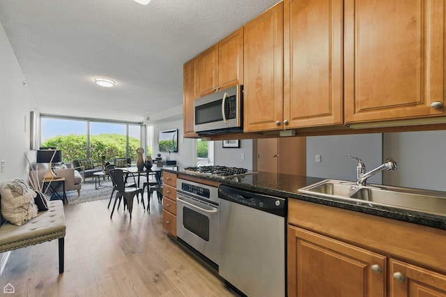 9715 Woods Dr Unit 805, Skokie, IL 60077 - kitchen with appliances with stainless steel finishes, light wood-style floors, dark countertops, brown cabinets, and a textured ceiling