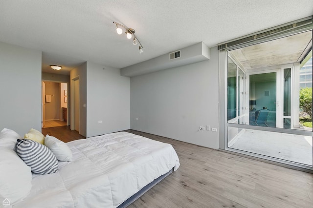 9715 Woods Dr Unit 805, Skokie, IL 60077 - bedroom with wood finished floors, a textured ceiling, and ensuite bathroom