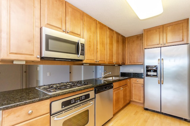 9715 Woods Dr Unit 805, Skokie, IL 60077 - kitchen with appliances with stainless steel finishes, a sink, light wood-style flooring, and dark stone countertops
