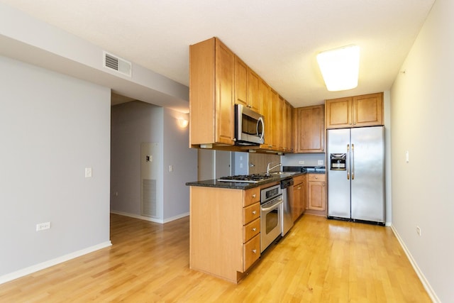 9715 Woods Dr Unit 805, Skokie, IL 60077 - kitchen with appliances with stainless steel finishes, light wood finished floors, baseboards, a sink, and brown cabinetry