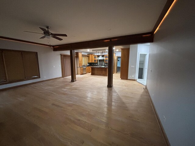 unfurnished living room with baseboards, light wood-style floors, and ceiling fan