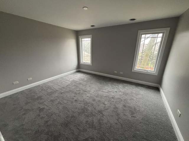carpeted empty room with visible vents and baseboards