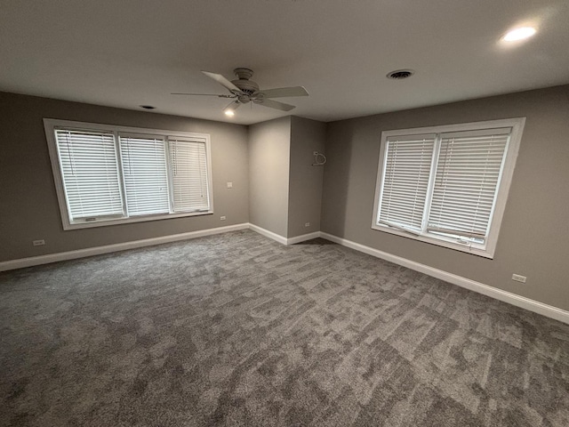empty room with baseboards, a ceiling fan, visible vents, and carpet flooring