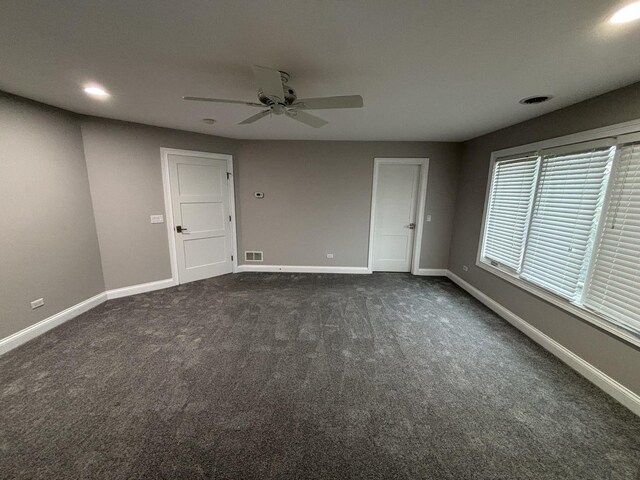 spare room featuring recessed lighting, dark colored carpet, and baseboards