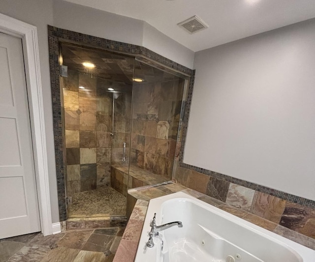 bathroom featuring a whirlpool tub, visible vents, and a stall shower
