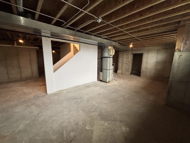 below grade area featuring heating unit and stairway