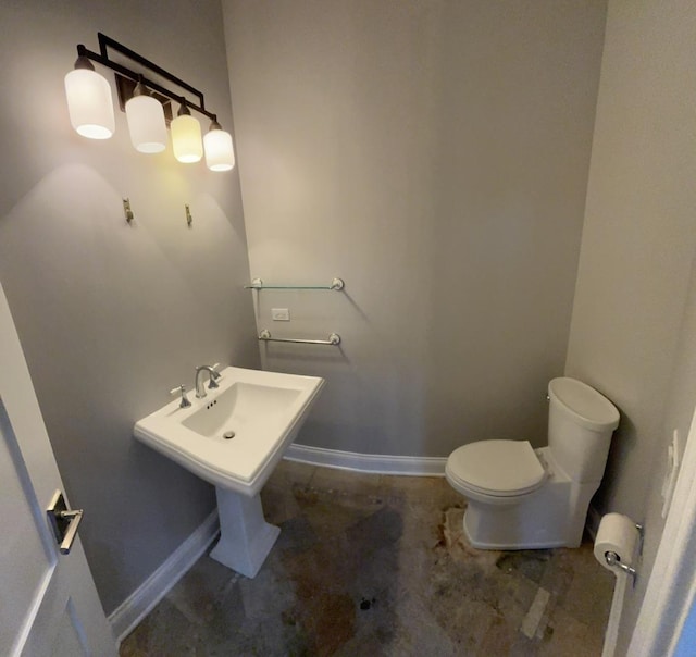 bathroom with toilet and baseboards