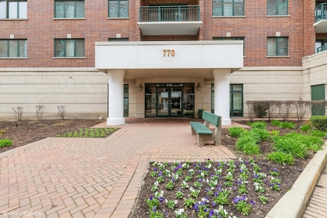 view of exterior entry featuring brick siding