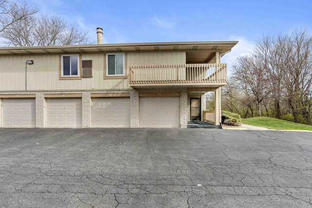 view of front facade featuring driveway, a balcony, and a garage