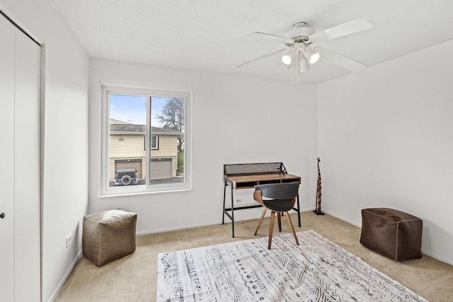 interior space with baseboards, a ceiling fan, carpet flooring, and a textured ceiling