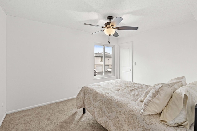 carpeted bedroom featuring baseboards, a textured ceiling, and ceiling fan