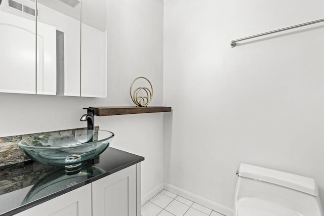 half bathroom featuring tile patterned floors, visible vents, toilet, vanity, and baseboards
