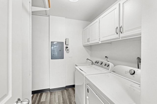 laundry room featuring light wood finished floors, electric panel, a sink, separate washer and dryer, and cabinet space