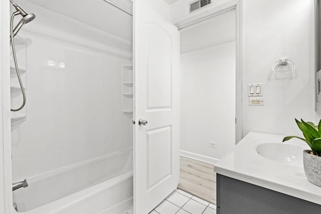 bathroom with tile patterned floors, vanity, tub / shower combination, baseboards, and visible vents
