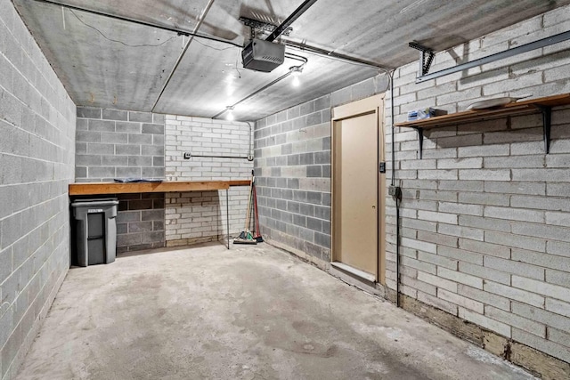 garage featuring a garage door opener and concrete block wall