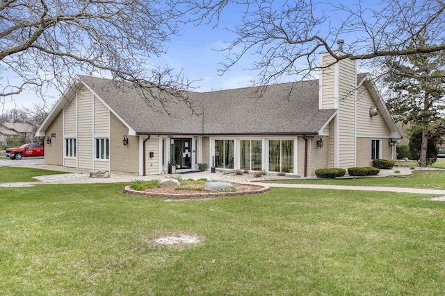 rear view of property with a lawn, brick siding, and a shingled roof