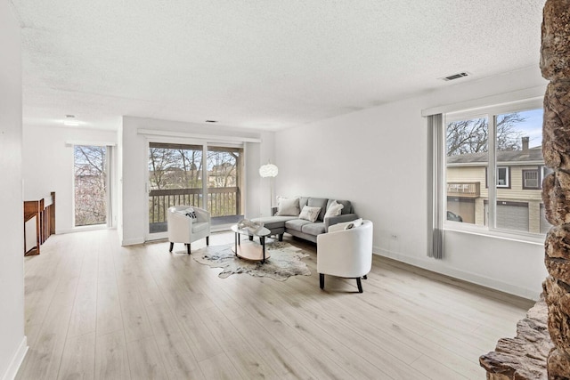 living room featuring a wealth of natural light, a textured ceiling, and visible vents